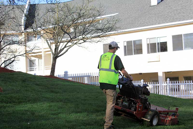 commercial landscaper mowing lawn